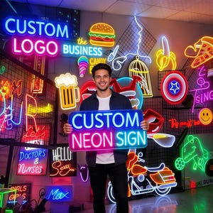May include: A man holding a blue and pink neon sign that reads "CUSTOM NEON SIGN." The background features various neon signs, including a burger, ice cream cone, and a Captain America shield. Other signs say "CUSTOM LOGO" and "DOCTORS & Nurses."