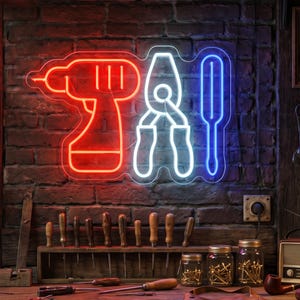 May include: A neon sign depicting a drill, pliers, and screwdriver in red, white, and blue, against a brick wall. Below, a wooden rack displays screwdrivers. Jars of nails and other tools are on a wooden surface.