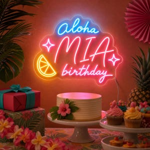 Può includere: Un'insegna al neon con supporto in acrilico trasparente che mostra il testo Aloha MIA birthday in corsivo blu, rosa e giallo. L'insegna presenta un'icona luminosa di una fetta di agrume gialla e due stelle a quattro punte.
