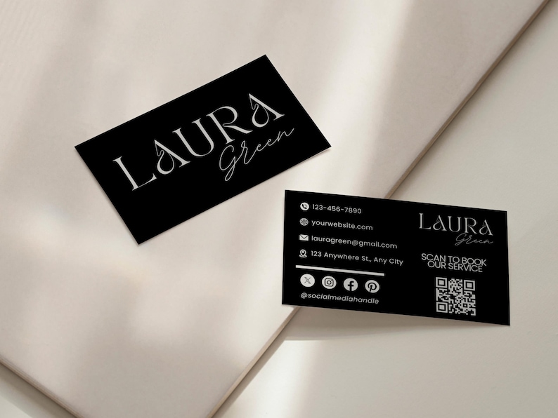 Op de afbeelding: Twee zwarte visitekaartjes met witte tekst. De kaarten tonen de naam "LAURA Green" in elegant schrift. E&eacute;n kaart bevat contactgegevens: telefoonnummer, website, e-mail en social media handles. Er is ook een QR-code aanwezig.