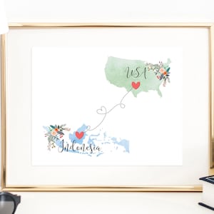 May include: A framed print featuring a watercolour map of the USA and Indonesia, connected by a dotted line with hearts. The text "USA" and "Indonesia" is written on the map.