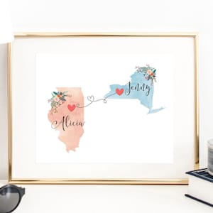 May include: A framed print with a watercolor illustration of the states of Illinois and New York connected by a dotted line with hearts. The text "Alicia" is written on the Illinois state and "Jenny" is written on the New York state.