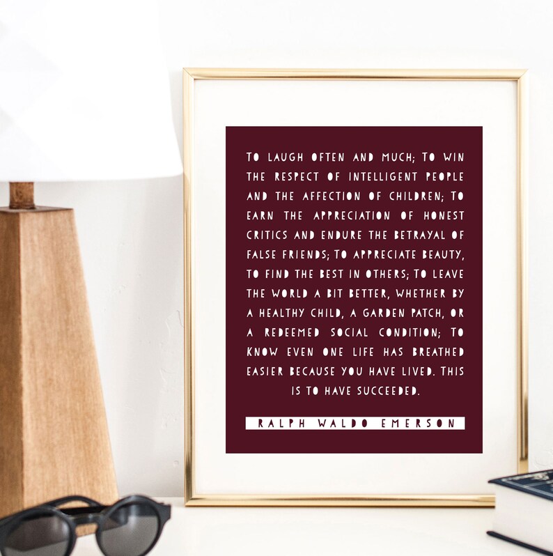 May include: A burgundy framed print with a white background and white text. The text is a quote by Ralph Waldo Emerson about living a good life. The quote reads: "To laugh often and much; to win the respect of intelligent people and the affection of children; to earn the appreciation of honest critics and endure the betrayal of false friends; to appreciate beauty, to find the best in others; to leave the world a bit better, whether by a healthy child, a garden patch, or a redeemed social condition; to know even one life has breathed easier because you have lived. This is to have succeeded."
