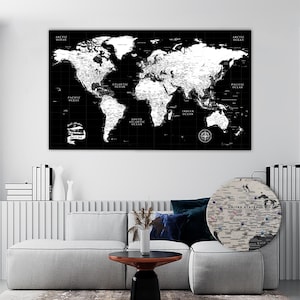 Può includere: Una grande decorazione murale rettangolare che presenta una mappa del mondo in bianco e nero con linee di griglia e una rosa dei venti. La mappa mostra i continenti in bianco su sfondo nero. È visibile anche una mappa circolare degli Stati Uniti.