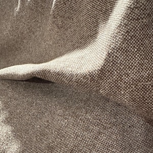 May include: Close-up of a brown and white textured fabric with a subtle woven pattern.