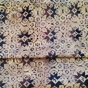May include: A beige and brown fabric with a repeating pattern of stylized flowers and geometric shapes. The fabric has a subtle tie-dye effect.