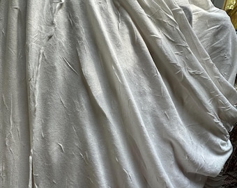Pleated polyester knit fabric in a pale shade of silver.   Matte finish.  Very lightweight.