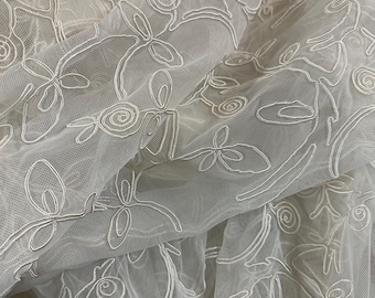 Soutache embroidered polyester tulle in bright white hue.  Eclectic pattern.