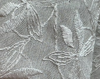 Poly/rayon embroidered chiffon fabric with a lovely tone on tone floral design.  Fabric surface is pearlized.