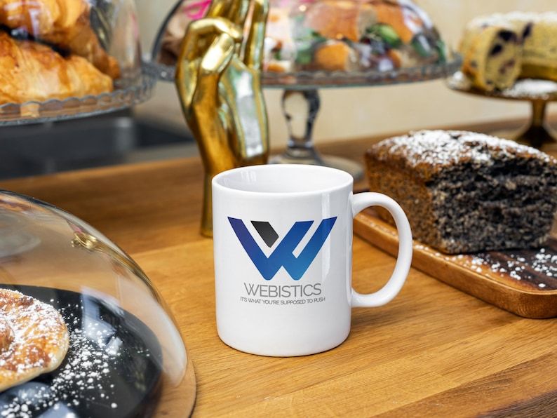 Sopranos-themed Webistics coffee mug on a café counter surrounded by pastries. Features Tony Soprano quote. Great gift idea for The Sopranos fans and lovers of mafia TV memorabilia.