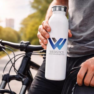 May include: A white water bottle with a silver cap and a blue and black logo that reads "WEBISTICS". The bottle is held by a person next to a black mountain bike. The background is blurred with trees and sunlight.