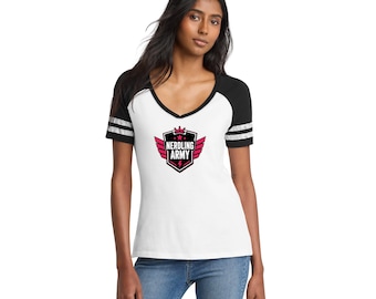 May include: A white V-neck t-shirt with black raglan sleeves featuring two white stripes on each sleeve. The center of the shirt displays a black and pink shield graphic with wings, a crown, and the text NERDLING ARMY in white capital letters.