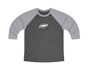 May include: A dark heather gray baseball shirt with light gray three-quarter length sleeves. The chest features a graphic with a small crown icon above the white text "COMICS AND..." set against a dark gray, textured, comic-style speech bubble.