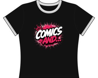 May include: A black short-sleeve t-shirt with white and grey trim on the collar and sleeves. The center features a graphic with a pink crown and the white text "COMICS AND..." set against a vibrant pink and white paint splatter background.
