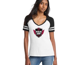May include: A white V-neck t-shirt with black raglan sleeves featuring two white stripes on each sleeve. The center of the shirt displays a black and pink shield graphic with wings, a crown, and the text NERDLING ARMY in white capital letters.