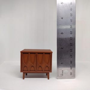 Dollhouse nightstand shown alongside a ruler.