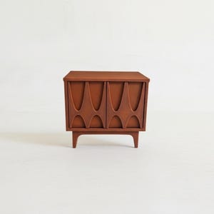 Miniature dollhouse nightstand in a brown retro 60s furniture style, with arched pattern door fronts.