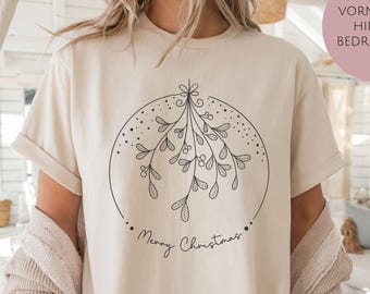 Könnte beinhalten: Sandfarbenes T-Shirt mit einer schwarzen Strichzeichnung von Mistelzweigen in einem Kreis und dem Schriftzug "Merry Christmas". Das Shirt hat hochgekrempelte Ärmel und eine lockere Passform. Der Text "VORNE UND HINTEN BEDRUCKBAR" befindet sich in einem rosa Kreis.