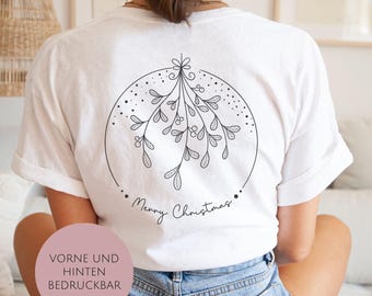 Könnte beinhalten: Weißes T-Shirt mit einem schwarzen Mistelzweig-Design in einem Kreis und dem Schriftzug "Merry Christmas". Ein festliches Oberteil aus weichem Material, ideal für die Weihnachtszeit.