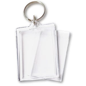 May include: A clear plastic photo frame keychain with a silver metal ring. The frame is designed to hold a small photo or other memento.
