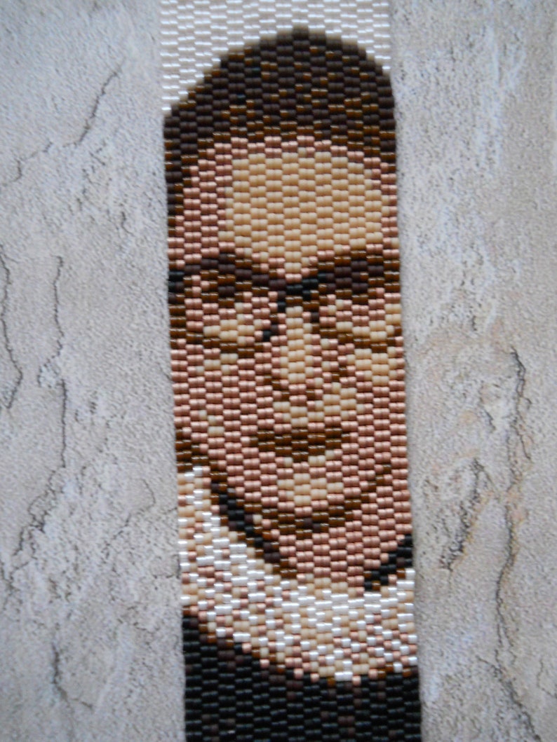 May include: A beaded portrait of a person wearing glasses and a white collar. The portrait is made with small, colorful beads.