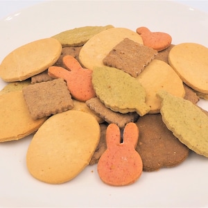 May include: A variety of homemade dog treats in different shapes and colors, including leaves, circles, and bunnies. The treats are made with natural ingredients and are perfect for training or rewarding your furry friend.