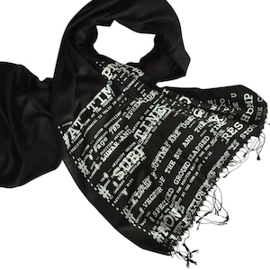 May include: Black scarf with white text printed on it. The text includes the words "AT TIM", "EPHEM", "SUBF", "JUTINES", "NONE", "HDMP", and "RES".