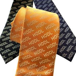 May include: Three neckties with a repeating pattern of the word "HODL" in white text on a dark blue, light blue, and orange background.