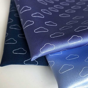 May include: Three pieces of fabric with a white cloud pattern. The fabric is in shades of blue, from dark blue to light blue.