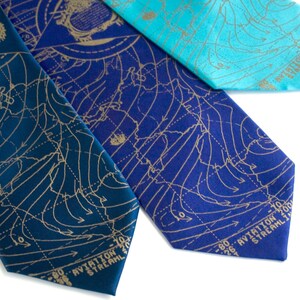 May include: Three silk ties with a weather map design in gold on a blue, teal, and dark blue background. The ties have the text "AVIATION STREAM" printed on the bottom.