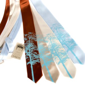 May include: Four silk ties with a blue tree silhouette design. The ties are in shades of brown, beige, and light blue.