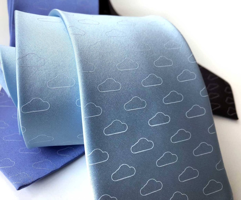 May include: A light blue tie with a white cloud pattern. The tie is made of a smooth, silky fabric.