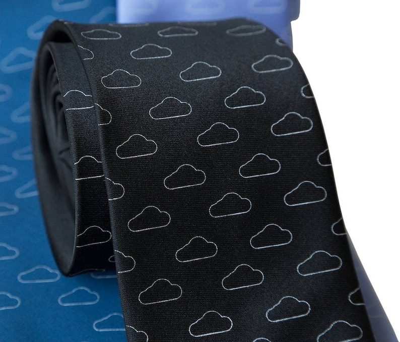 May include: A black silk tie with a white cloud pattern. The tie is rolled up and partially visible.