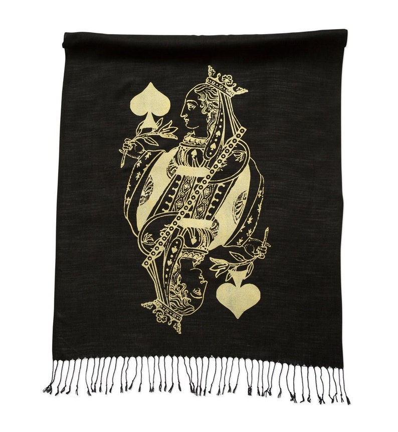 May include: Black scarf with a gold Queen of Spades design. The scarf has a fringe border.