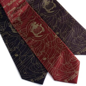 May include: Three silk neckties with a map-like pattern in gold on a dark background. The ties are in burgundy, dark purple, and black. The text on the ties reads "Aviation Streamline 100".