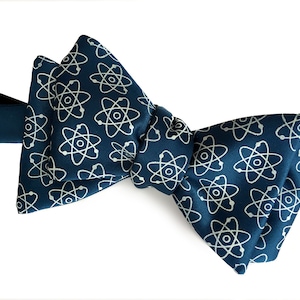 May include: A dark blue bow tie with a white atom pattern.