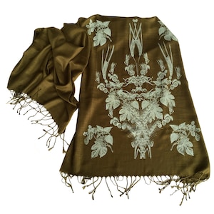 May include: A brown silk scarf with a white print of wheat and hops. The scarf has fringe on the ends.