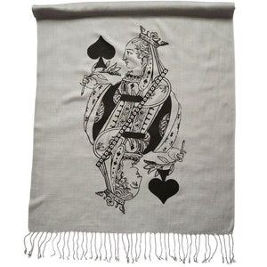 May include: A gray scarf with a black and white image of the Queen of Spades playing card. The scarf has a fringe border.