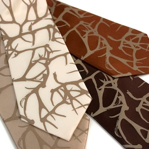 May include: Four neckties in shades of beige, cream, brown, and dark brown, each featuring a repeating abstract branch pattern in a contrasting color. The ties are arranged diagonally, showcasing their varying colors and designs.