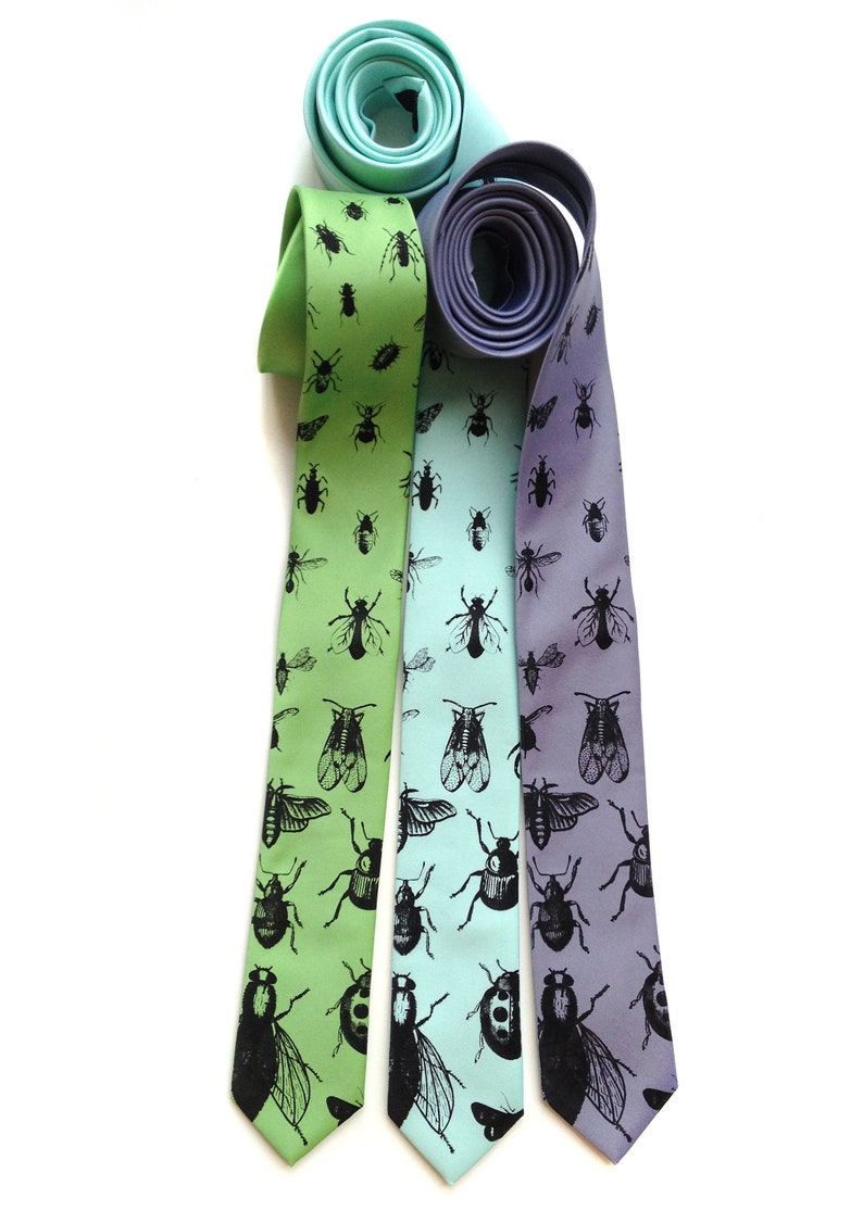 May include: Three silk neckties with a pattern of black insects on a light green, light blue, and purple background.