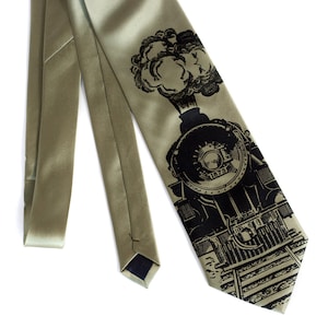 May include: A green silk tie with a black and white illustration of a steam locomotive with the number 1873 on the front.