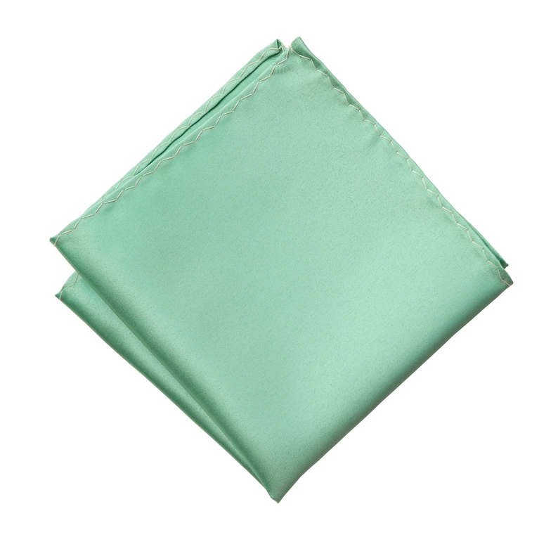Puede incluir: Un pa&ntilde;uelo de bolsillo de seda verde doblado.
