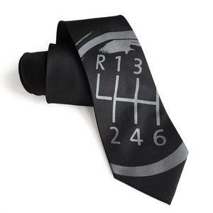 May include: A black silk tie with a silver gray gear shift pattern and the numbers R, 1, 3, 4, 5, 6, and 2.