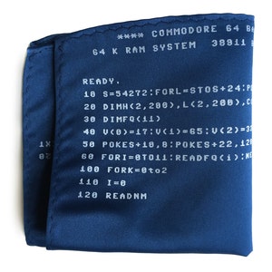 May include: A blue fabric pocket square with white text that reads "**** COMMODORE 64 BASIC 64 K RAM SYSTEM 38911 READY. 10 S=54272:FORL=STOS+24:P 20 DIMH(2,208),L(2,208),C 30 DIMFQ(11) 40 V(0)=17:V(1)=65:V(2)=33 50 POKES+10,8:POKES+22,128 60 FORI=0TO11:READFQ(i):NE 100 FORK=0to2 110 I=0 120 READNM"
