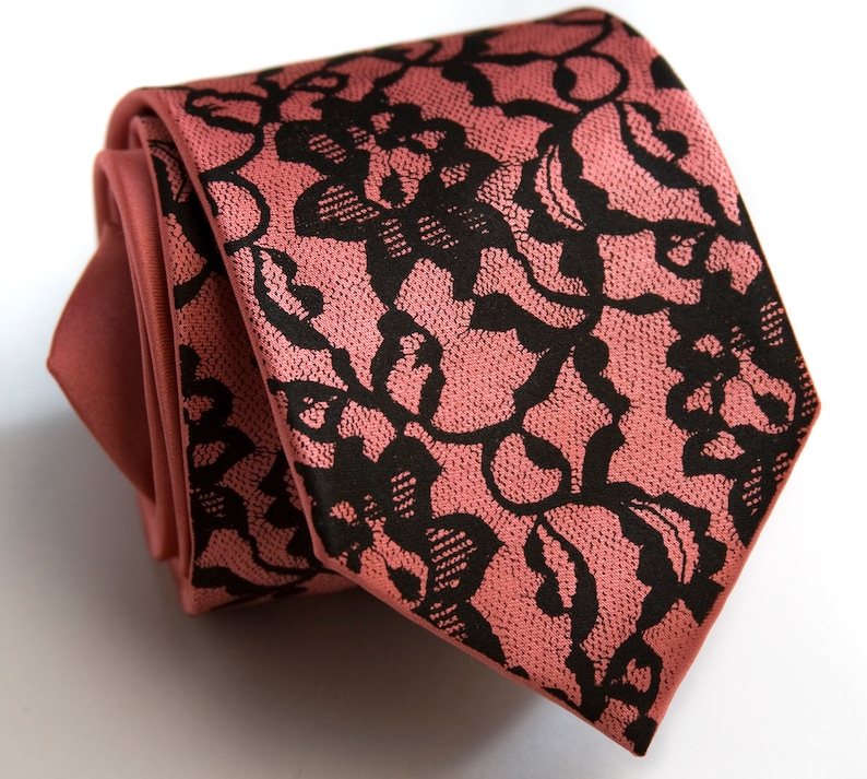 May include: A pink tie with a black lace pattern.