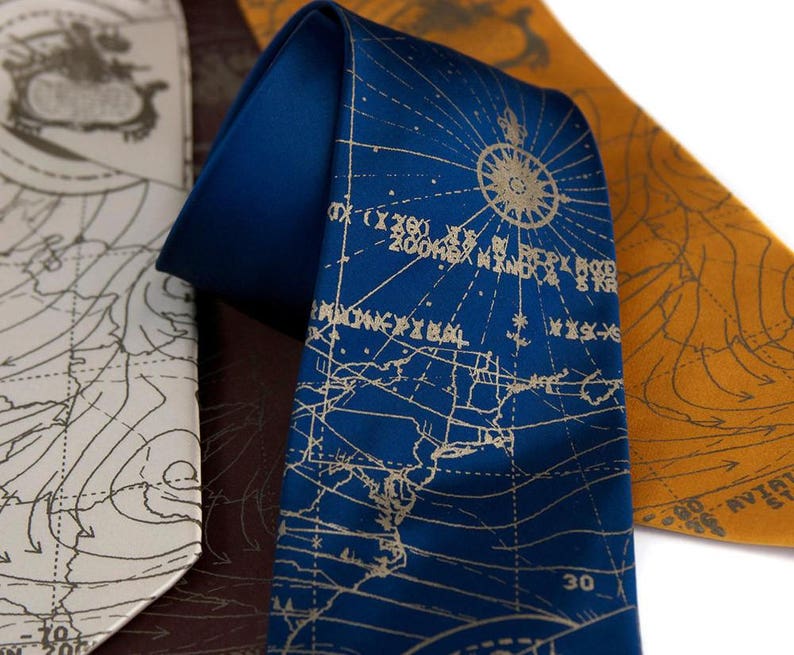 May include: Three silk neckties with a map design. The ties are in blue, white, and orange. The blue tie has a compass rose and the text "30" printed on it.