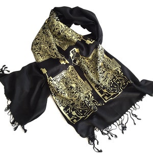 May include: A black scarf with a gold circuit board pattern. The scarf has fringe on the ends.
