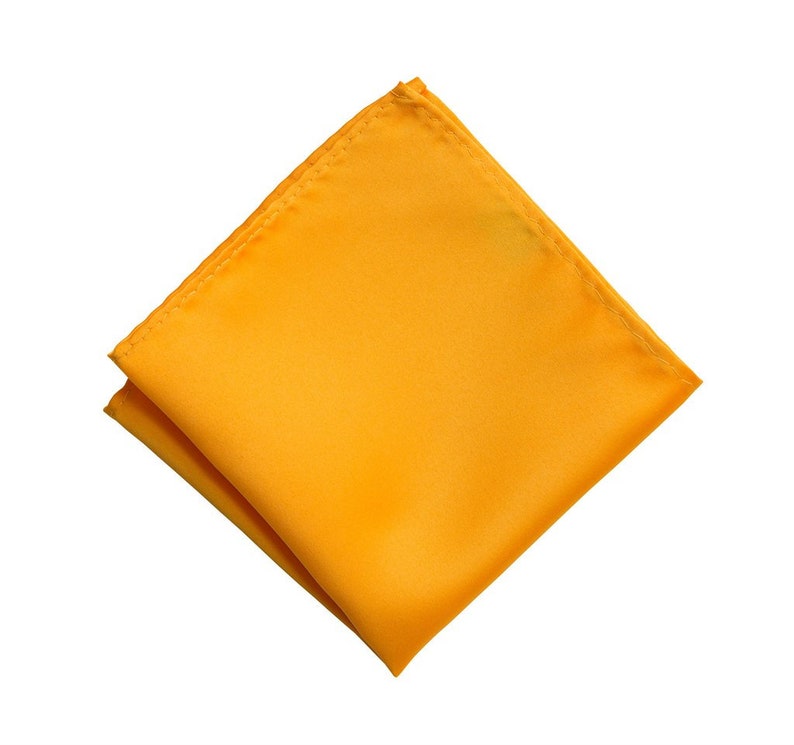 Puede incluir: Un pa&ntilde;uelo de bolsillo amarillo s&oacute;lido. El cuadrado est&aacute; doblado por la mitad y est&aacute; hecho de una tela suave y sedosa.