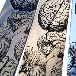 May include: Three silk ties with a black and white anatomical brain print. The ties are on a white background.