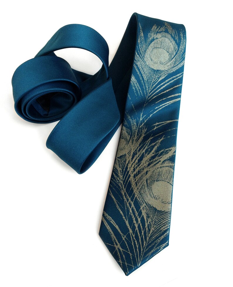 May include: A teal blue silk tie with a gold peacock feather pattern.